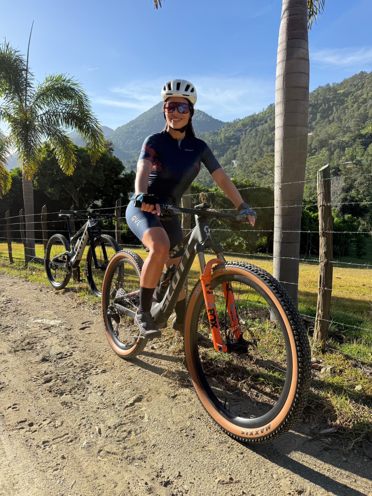 Mountain biker on a trail with palm trees and green hills in Jarabacoa